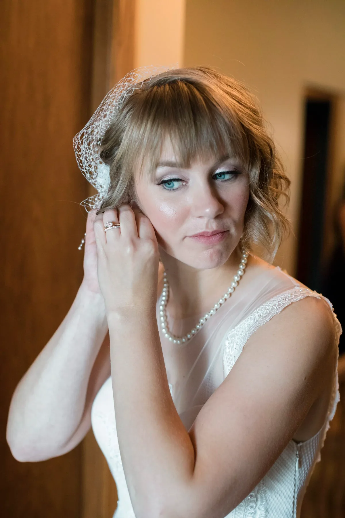 Bride in a birdcage veil and pearls with bridal makeup by Evolution of Beauty in Marshall, Minnesota